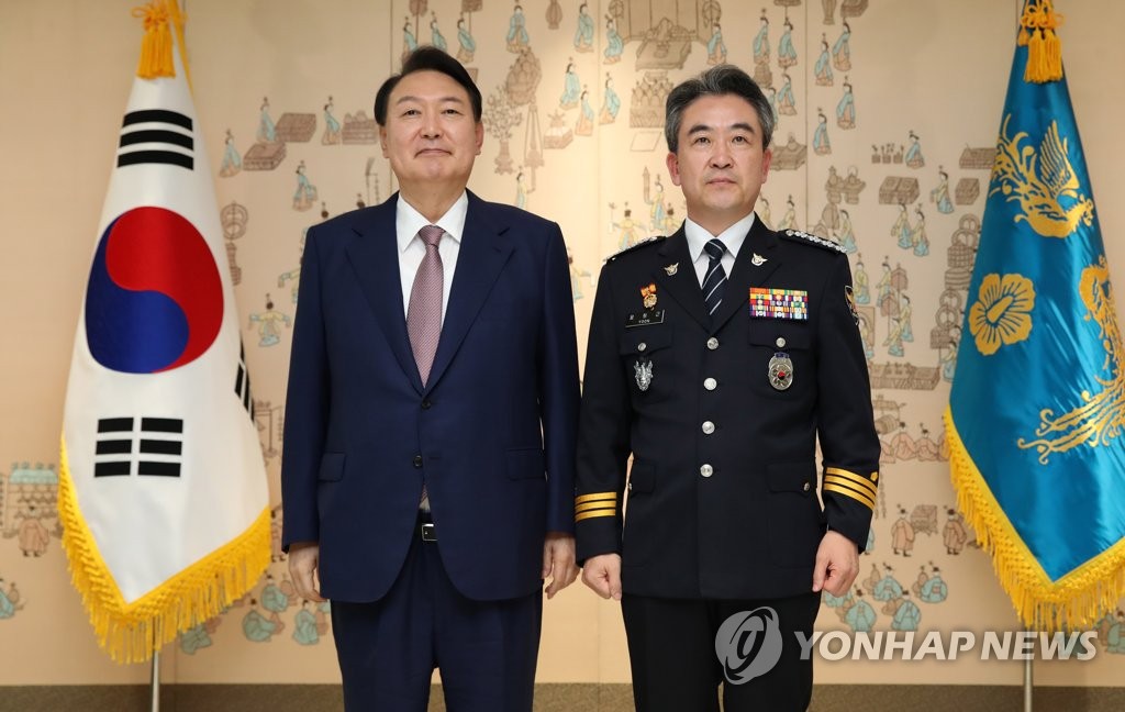 President Yoon Suk-yeol (L) poses for a photo with Yoon Hee-keun, new head of the National Police Agency, after presenting him with a letter of appointment at the presidential office in Seoul on Aug. 10, 2022. (Pool photo) (Yonhap)