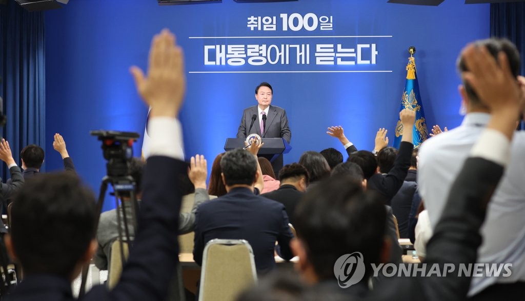Reporters raise their hands to ask questions to President Yoon Suk-yeol during a press conference marking his first 100 days in office at the presidential office in Seoul on Aug. 17, 2022. (Yonhap)