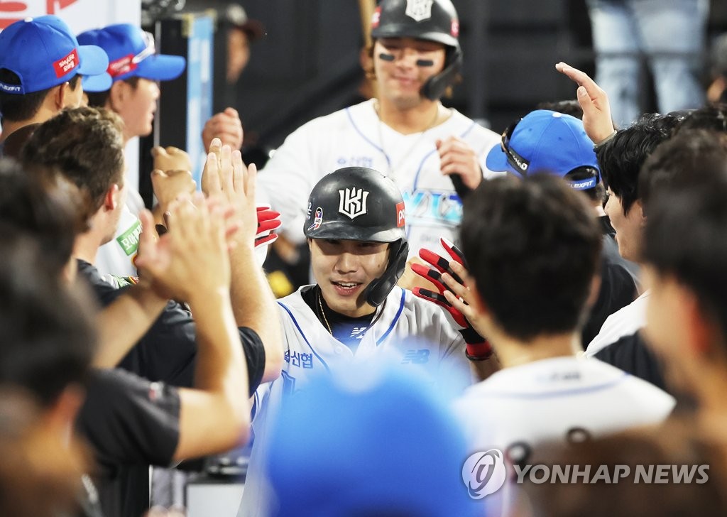 Shim Woo-jun of the KT Wiz (C) is congratulated by teammates in the dugout after hitting a three-run home run against the Kia Tigers during the bottom of the seventh inning of a Korea Baseball Organization regular season game at KT Wiz Park in Suwon, nearly 35 kilometers south of Seoul, on Aug. 21, 2022. (Yonhap)