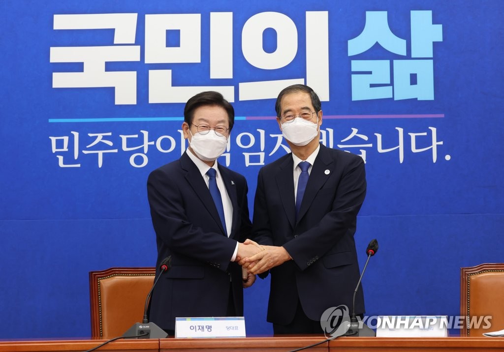 Prime Minister Han Duck-soo (R) and Lee Jae-myung, new leader of the Democratic Party, pose for a photo before holding a meeting on Sept. 1, 2022. (Pool photo) (Yonhap)