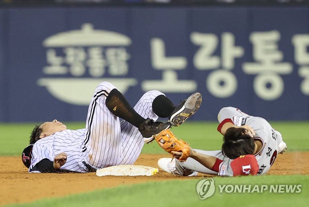 Kim Hyun-soo of the LG Twins (L) and Park Seong-han of the SSG Landers lie on the ground after their collision at second base during the bottom of the 11th inning of a Korea Baseball Organization regular season game at Jamsil Baseball Stadium in Seoul on Sept. 7, 2022. (Yonhap)