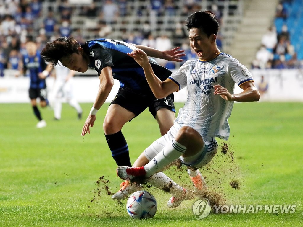 Kim Bo-sub of Incheon United (L) and Lim Jong-eun of Ulsan Hyundai FC battle for the ball during the clubs' K League 1 match at Incheon Football Stadium in Incheon, 30 kilometers west of Seoul, on Sept. 14, 2022. (Yonhap)