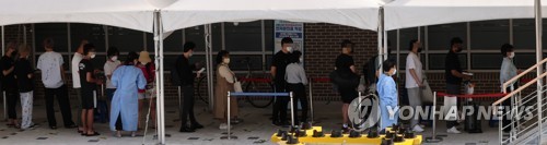 新型コロナウイルス検査所で順番を待つ人々＝（聯合ニュース）