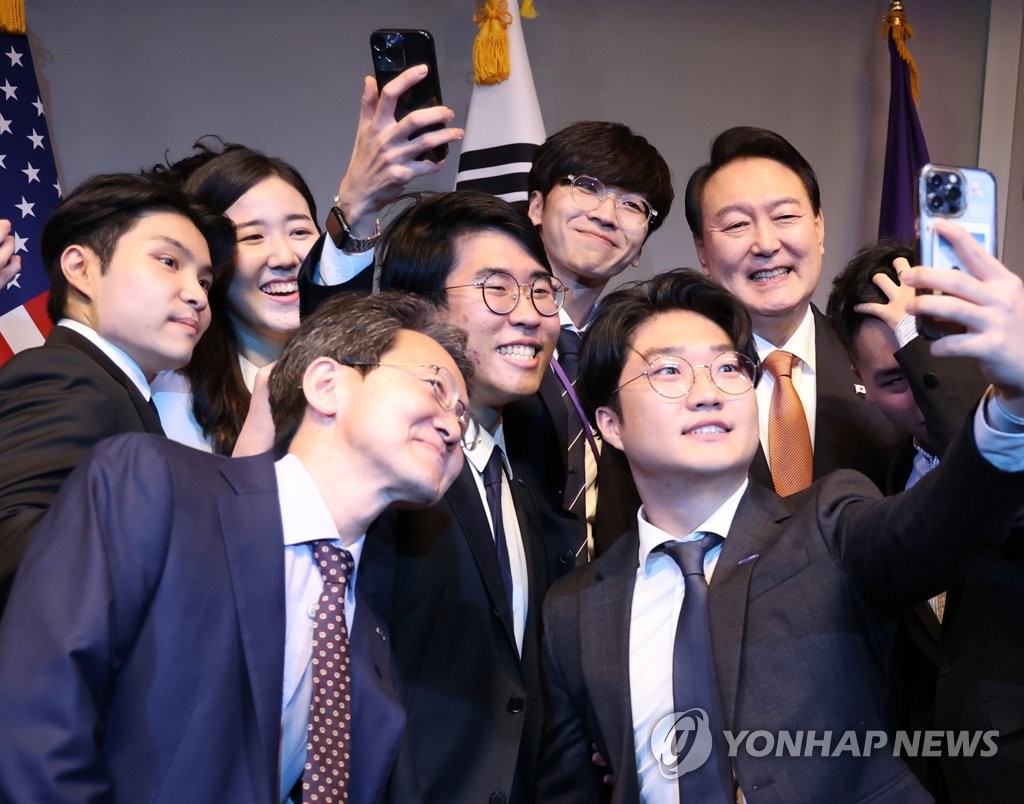 El presidente surcoreano, Yoon Suk-yeol (dcha., fondo), se toma una selfi con un grupo de estudiantes después de asistir a un foro de visión digital, celebrado, el 21 de septiembre de 2022 (hora local), en la Universidad de Nueva York (NYU, según sus siglas en inglés).