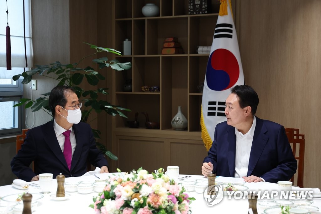 President Yoon Suk Yeol (R) talks with Prime Minister Han Duck-soo during their weekly meeting at the presidential office in Seoul on Sept. 26, 2022, in this file photo provided by the office. (PHOTO NOT FOR SALE) (Yonhap)