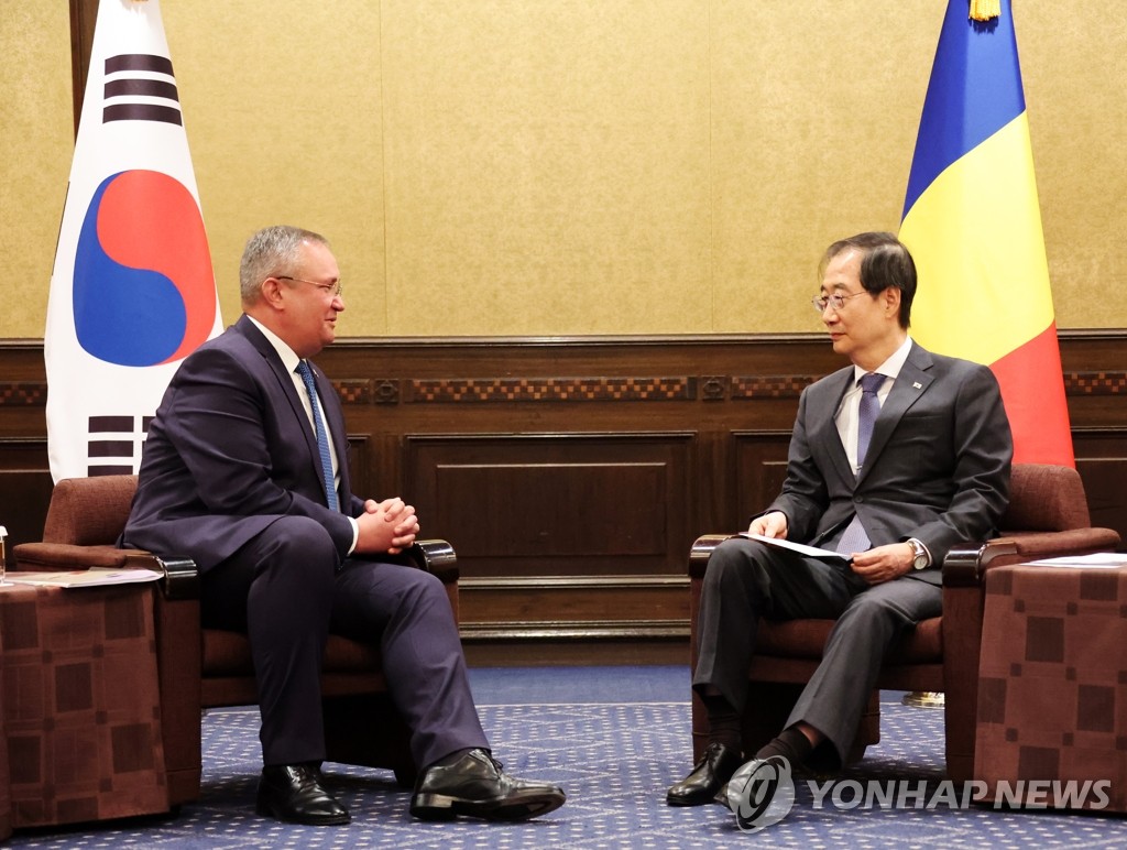 El primer ministro de Corea del Sur, Han Duck-soo (dcha.), dialoga con su homólogo rumano, Nicolae Ciuca, durante una reunión bilateral, celebrada, el 28 de septiembre de 2022, en un hotel de Tokio, Japón. 