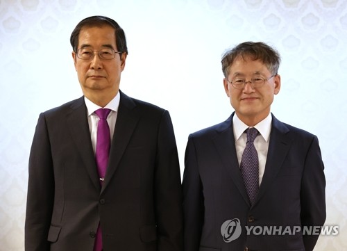 韓悳洙（ハン・ドクス）首相（左）と崔京林氏（資料写真）＝（聯合ニュース）