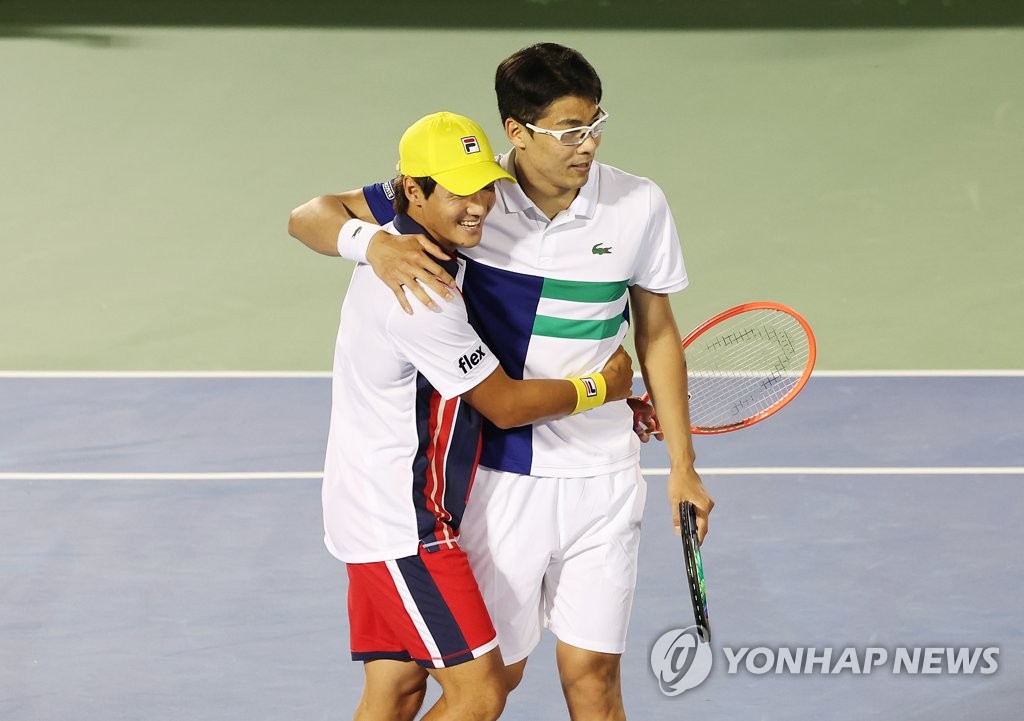 Los jugadores surcoreanos Kwon Soon-woo (izda.) y Chung Hyeon celebran su primera victoria, el 30 de septiembre de 2022, sobre Andre Goransson de Suecia y Ben McLachlan de Japón, en los cuartos de final de dobles masculinos del Abierto de Corea del Sur de la Asociación de Tenistas Profesionales, en el Centro de Tenis del Parque Olímpico en Seúl.