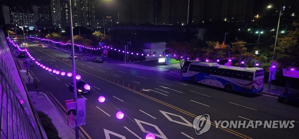 A road around the Busan Asiad Main Stadium in Busan, 325 kilometers southeast of Seoul, is lit up in purple on Oct. 13, 2022, as supergroup BTS was to hold a live concert there on Oct. 15 to support the city's bid to host the 2030 World Expo. The road was named "Bora Road," which means purple road. (Yonhap)