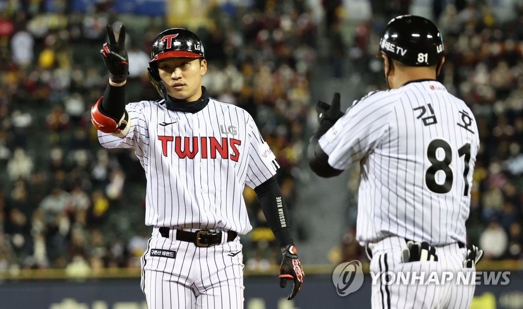 Park Hae-min of the LG Twins (L) celebrates his single against the Kiwoom Heroes during the bottom of the first inning of Game 1 of the second round in the Korea Baseball Organization postseason at Jamsil Baseball Stadium in Seoul on Oct. 24, 2022. (Yonhap)