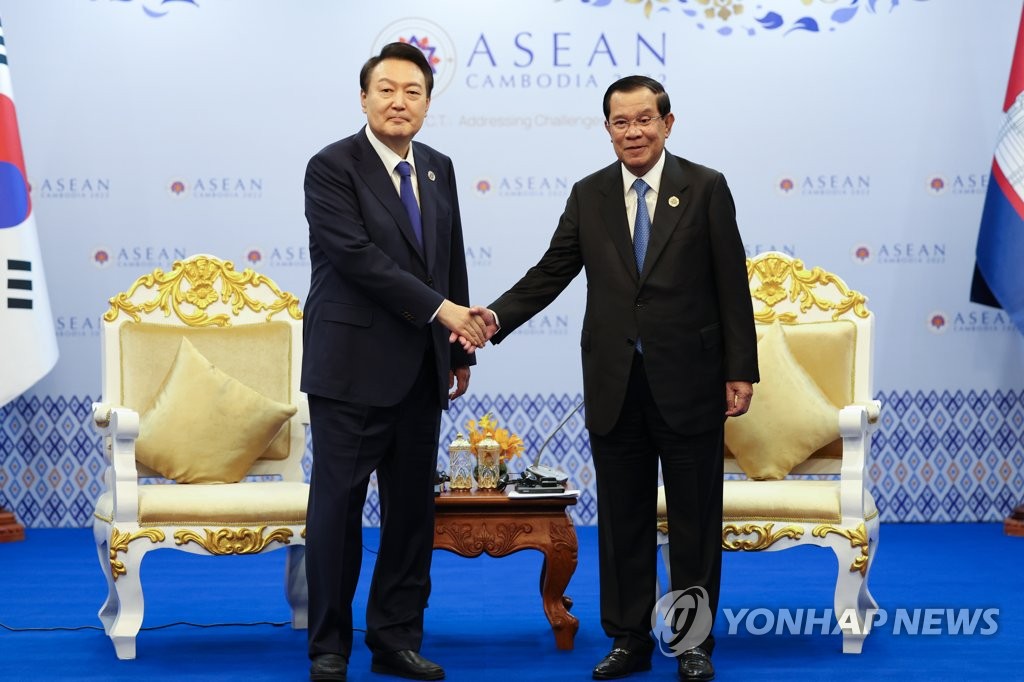 President Yoon Suk-yeol (L) and Cambodian Prime Minister Hun Sen shake hands during their summit at a hotel in Phnom Penh on Nov. 11, 2022. (Yonhap)