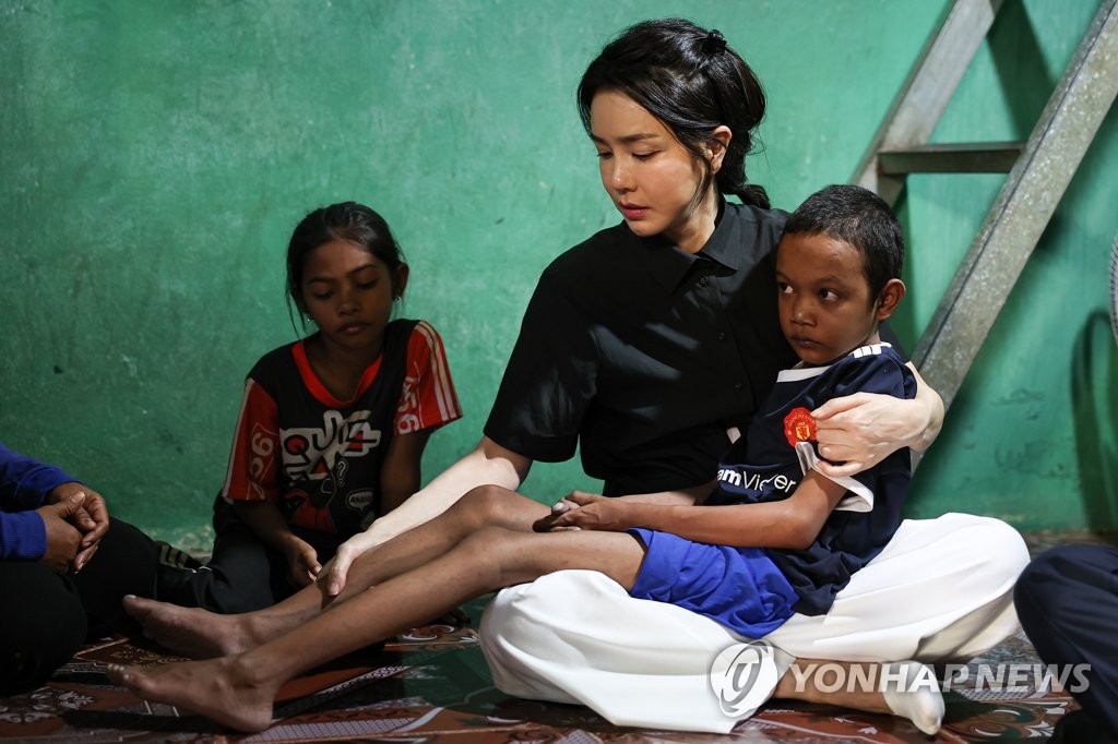 Kim Keon-hee, épouse du président Yoon Suk-yeol, porte dans ses bras un enfant souffrant d'une anomalie cardiaque congénitale au domicile de ce dernier à Phnom Penh, le samedi 12 novembre 2022 (Photo fournie par le bureau présidentiel. Revente et archivage interdits) 