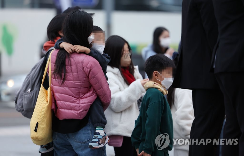 서울 광화문광장에서 두툼한 옷을 입은 한 어린이가 엄마품에 안겨있다. [연합뉴스 자료사진]