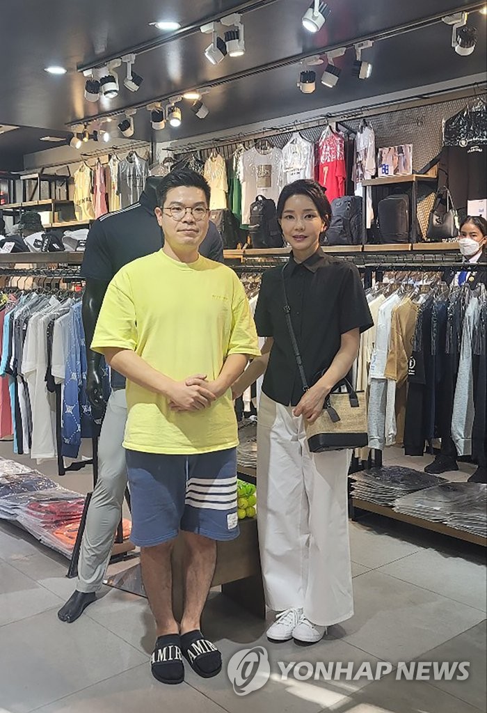 First lady Kim Keon-hee (R) poses for a photo with a South Korean running a retail store in Phnom Penh on Nov. 13, 2022, in this photo provided by the presidential office. (PHOTO NOT FOR SALE) (Yonhap)