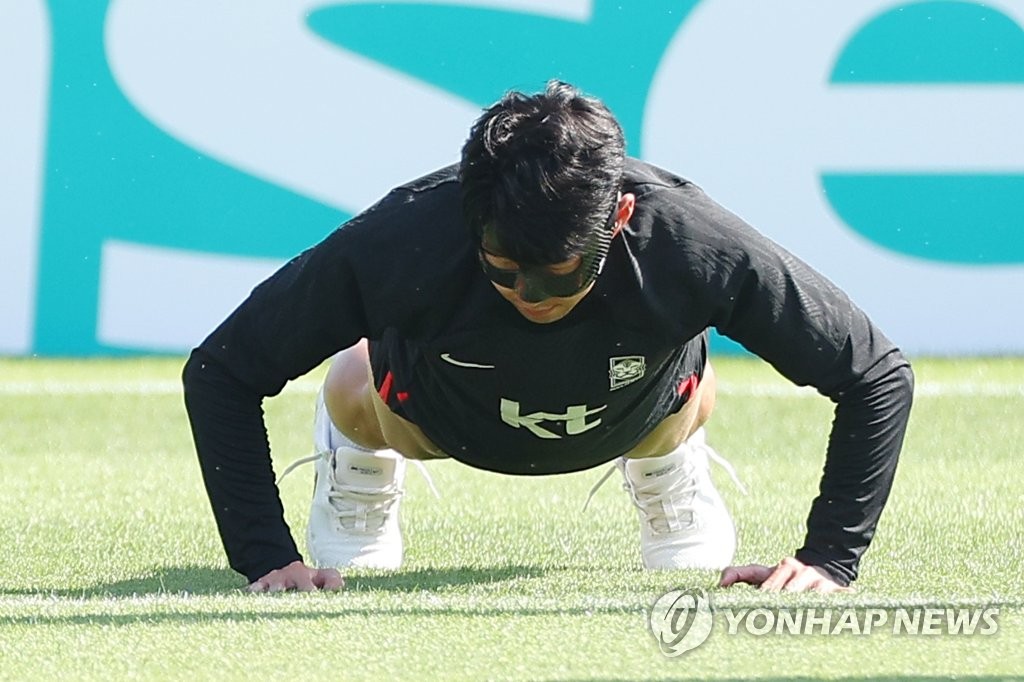 El capitán de la selección surcoreana, Son Heung-min, entrena utilizando una máscara negra sobre su rostro lastimado, el 17 de noviembre de 2022, en la Instalación de Entrenamiento Al Egla en Doha, Catar, cuatro días antes de la inauguración de la Copa Mundial 2022.