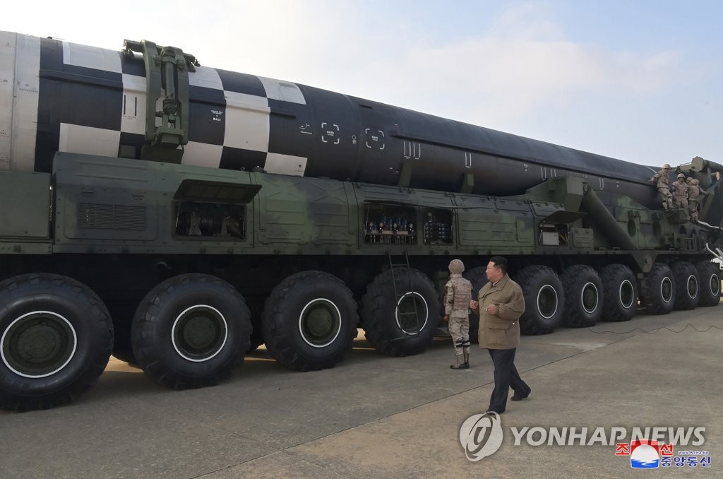 North Korean leader Kim Jong-un takes a look at a Hwasong-17 intercontinental ballistic missile (ICBM) on a Transporter Erector Launcher (TEL) ahead of its launch at Pyongyang International Airport, in this photo released by the country's state media. (For Use Only in the Republic of Korea. No Redistribution) (Yonhap)