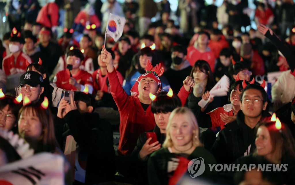 Las personas alientan a la selección nacional de fútbol durante la Copa Mundial de Catar, el 24 de noviembre de 2022, en la plaza de Gwanghwamun, en el centro de Seúl, antes del primer partido del Grupo H, entre Corea del Sur y Uruguay. 