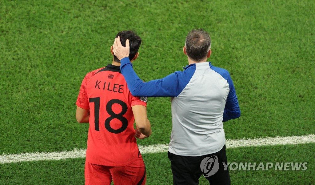 South Korea head coach Paulo Bento (R) prepares to send midfielder Lee Kang-in into the team's Group H match against Ghana at the FIFA World Cup at Education City Stadium in Al Rayyan, west of Doha, on Nov. 28, 2022. (Yonhap)