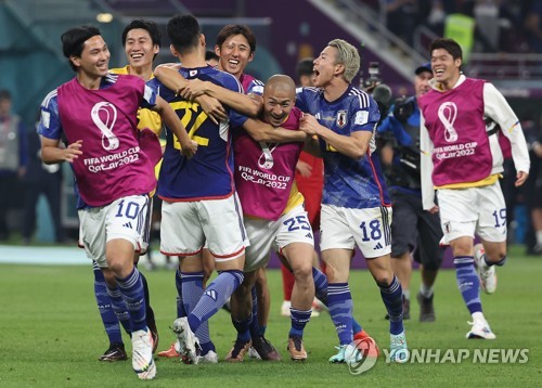 Japanese players celebrate their 2-1 win over Spain in the countries' Group E match at the FIFA World Cup at Khalifa International Stadium in Al Rayyan, west of Doha, on Dec. 1, 2022. (Yonhap)