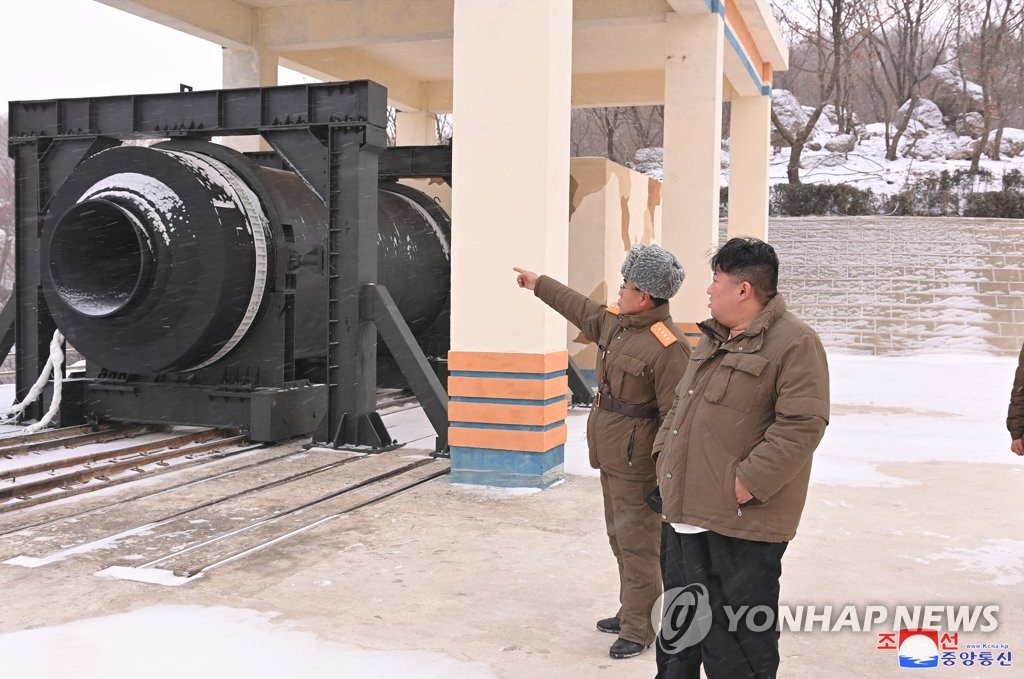 North Korean leader Kim Jong-un (R) looks at a "high-thrust solid-fuel motor" during its ground test at Sohae Satellite Launching Ground in Cholsan, North Pyongan Province, North Korea, on Dec. 15, 2022, in this photo released by the North's Korean Central News Agency. (For Use Only in the Republic of Korea. No Redistribution) (Yonhap)
