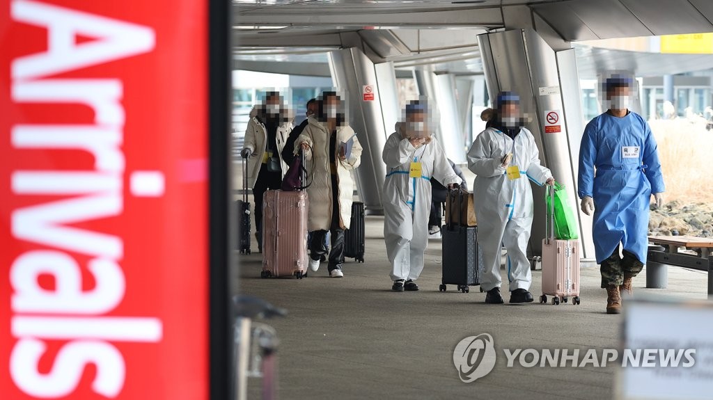 仁川空港の新型コロナ検査センターへ向かう中国からの入国者＝５日、仁川（聯合ニュース）