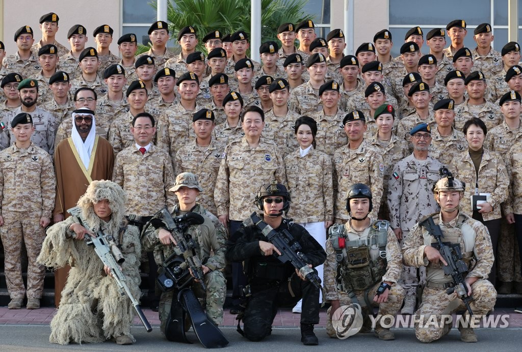 El presidente surcoreano, Yoon Suk Yeol (quinto por la izda., segunda fila.), y la primera dama, Kim Keon Hee (cuarta por la dcha., segunda fila), posan para una fotografía grupal durante una reunión con los soldados de la unidad militar surcoreana Akh, celebrada, el 15 de enero de 2023 (hora local), en Abu Dabi, los Emiratos Árabes Unidos.