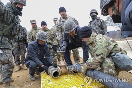 Des troupes logistiques de la Corée du Sud et des Etats-Unis raccordent un tuyau pour installer un réservoir de carburant dans le comté frontalier de Cheorwon, dans la province du Gangwon, à 71 kilomètres au nord-est de Séoul, dans le cadre d'un exercice conjoint de soutien logistique de cinq jours qui a débuté le 13 mars 2023. (Photo fournie par l'armée de terre sud-coréenne. Revente et archivage interdits) 