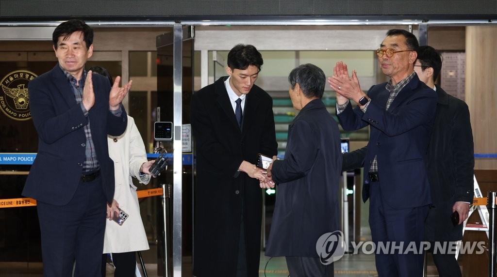 Chun Woo-won (C), a grandson of late former President Chun Doo-hwan, is greeted by members of civic groups commemorating the 1980 pro-democracy uprising in Gwangju, as he is released from the Mapo Police Station in Seoul on March 29, 2023. He was detained for investigation over suspected illegal drug use upon his arrival at Incheon International Airport the previous day. Recently, Chun Woo-won referred to his grandfather as "a slaughterer" due to the military's brutal suppression of the Gwangju uprising after he seized power through a coup in 1979. (Yonhap)