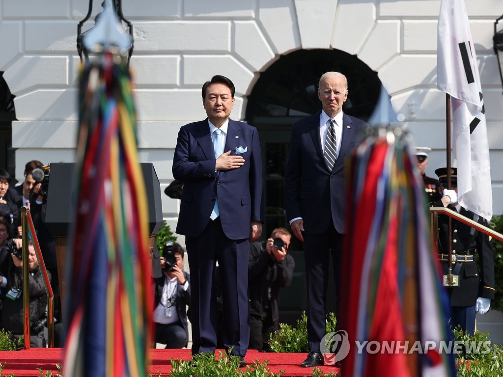 South Korean President Yoon Suk Yeol (L) and U.S. President Joe Biden attend an official welcoming ceremony ahead of their summit at the White House in Washington, D.C., on April 26, 2023. (Yonhap)