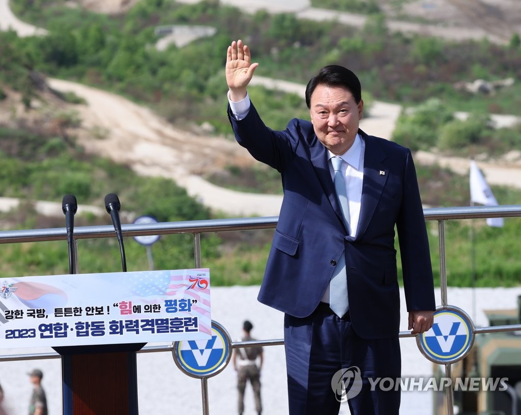 President Yoon Suk Yeol waves during live-fire drills staged jointly by South Korean and U.S. forces at the Seungjin Fire Training Field in Pocheon, just 25 kilometers south of the inter-Korean border, on June 15, 2023. The Combined Joint Live-Fire Exercise, the first of its kind in six years, was held, to mark the 70th anniversary of the South Korea-U.S. alliance and the 75th anniversary of the founding of South Korea's armed forces. (Yonhap)