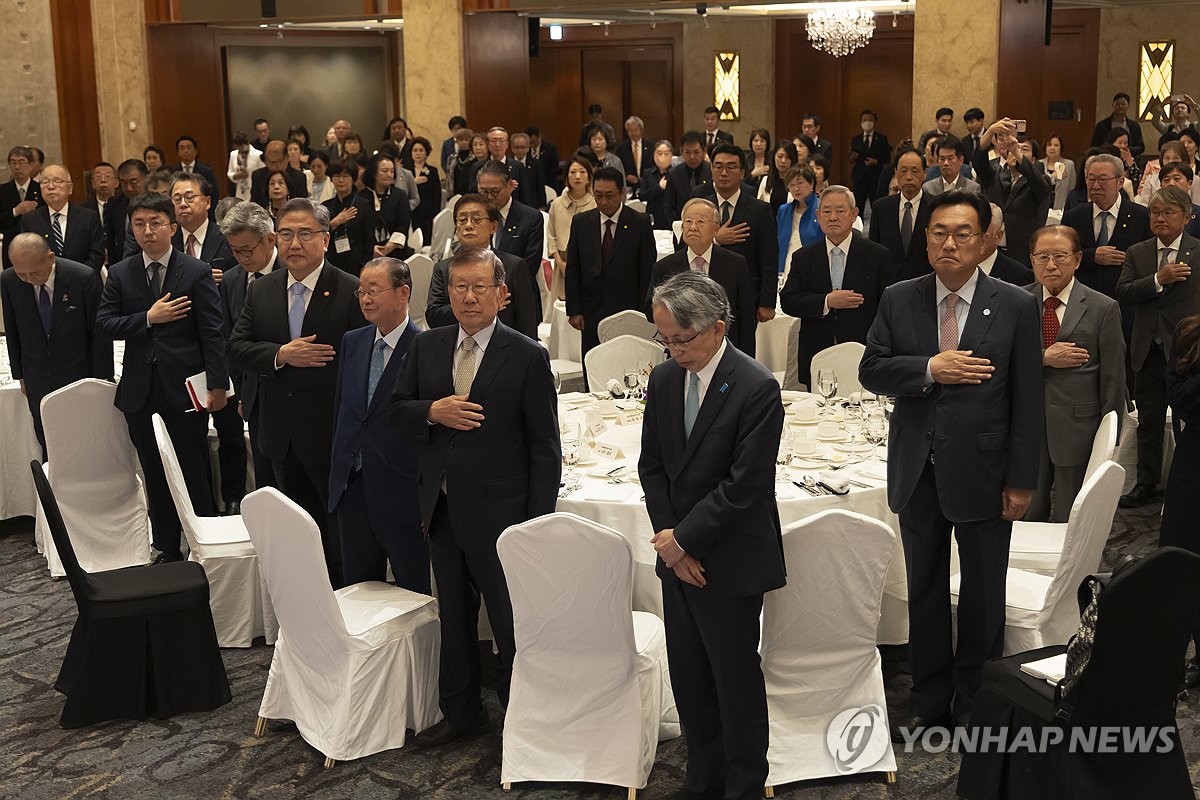 Participants salute the flag during a conference co-hosted by the Korea-Japan Friendship Association and the Japan-Korea Friendship Association at a hotel in Seoul on Oct. 13, 2023. (Yonhap)