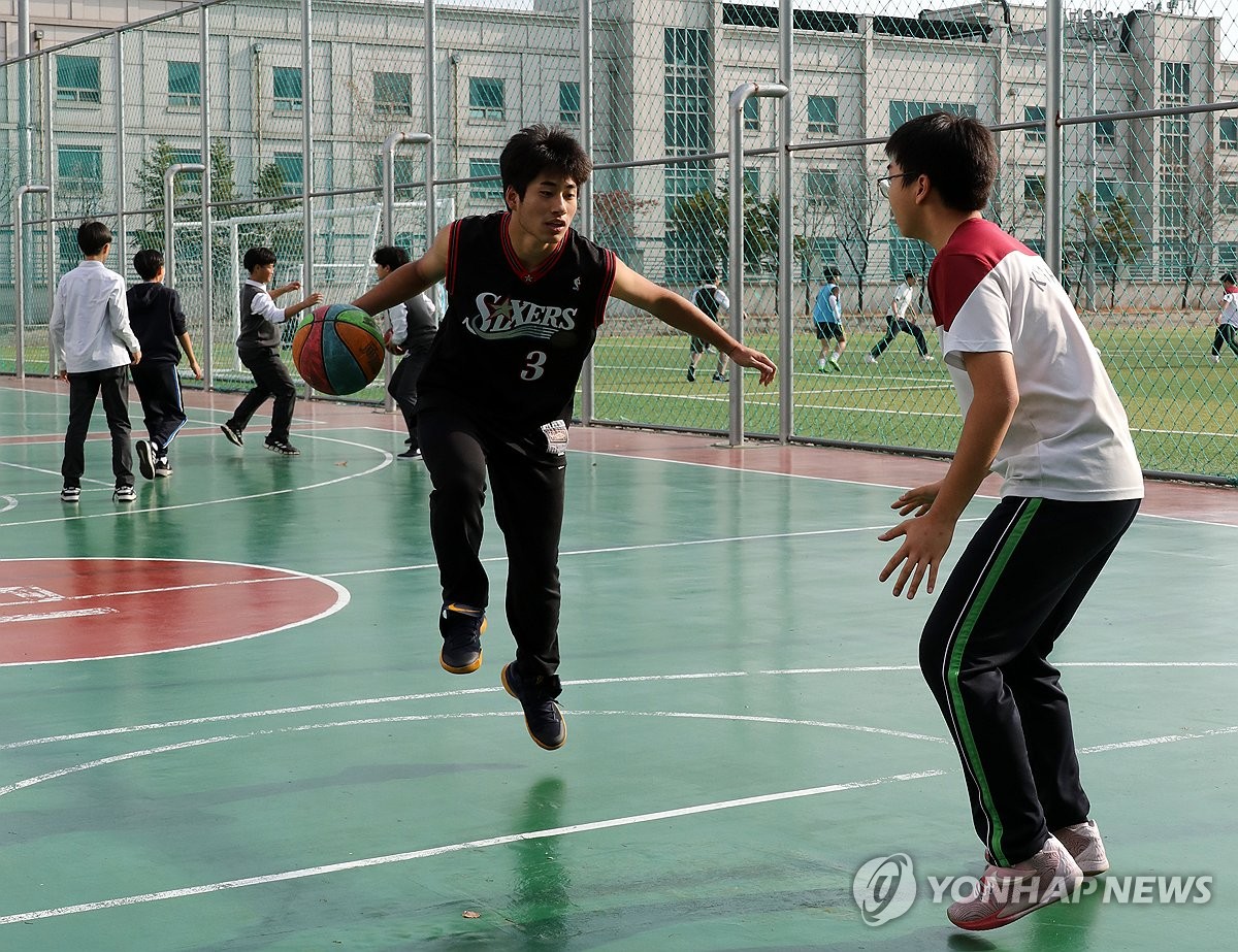 겨울 같지 않게 포근한 날씨를 보인 8일 오후 서울 동대문구 한 고등학교에서 학생들이 반소매를 입고 농구를 즐기고 있다. / 연합뉴스