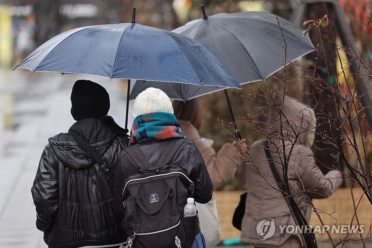 털모자와 우산을 쓴 사람들 / 연합뉴스