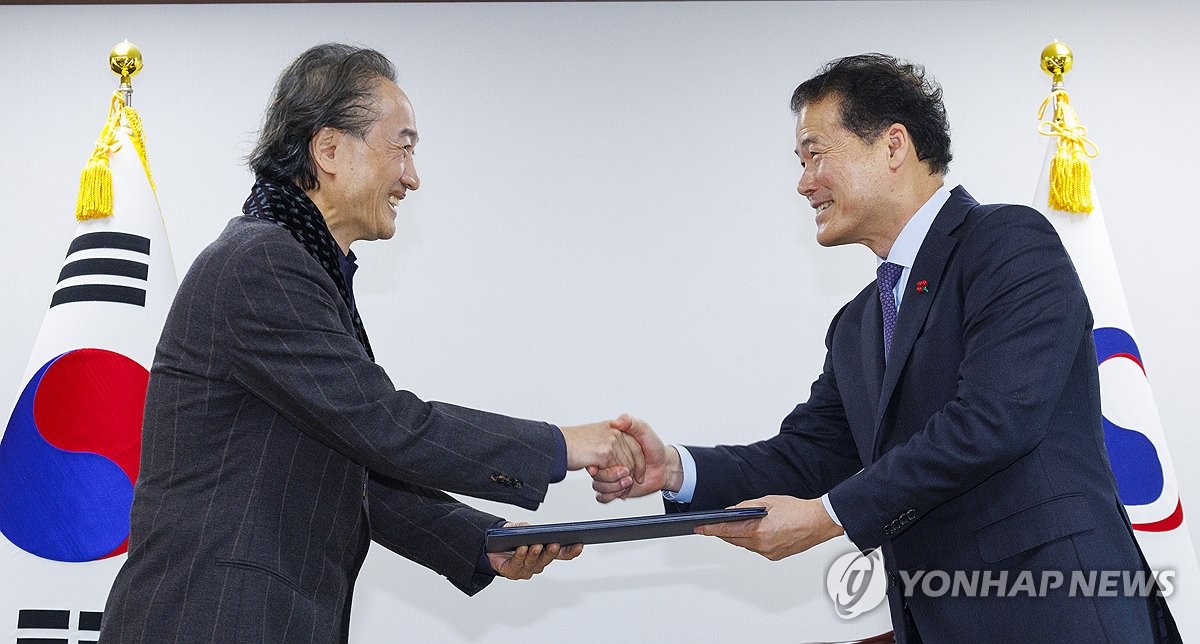 El ministro de Unificación, Kim Yung-ho (derecha), estrecha la mano del artista Yoo Keun-sang cuando lo nombra asesor especial para un proyecto para construir el Centro Nacional de Derechos Humanos de Corea del Norte en el oeste de Seúl, el 12 de enero de 2024. (Yonhap)