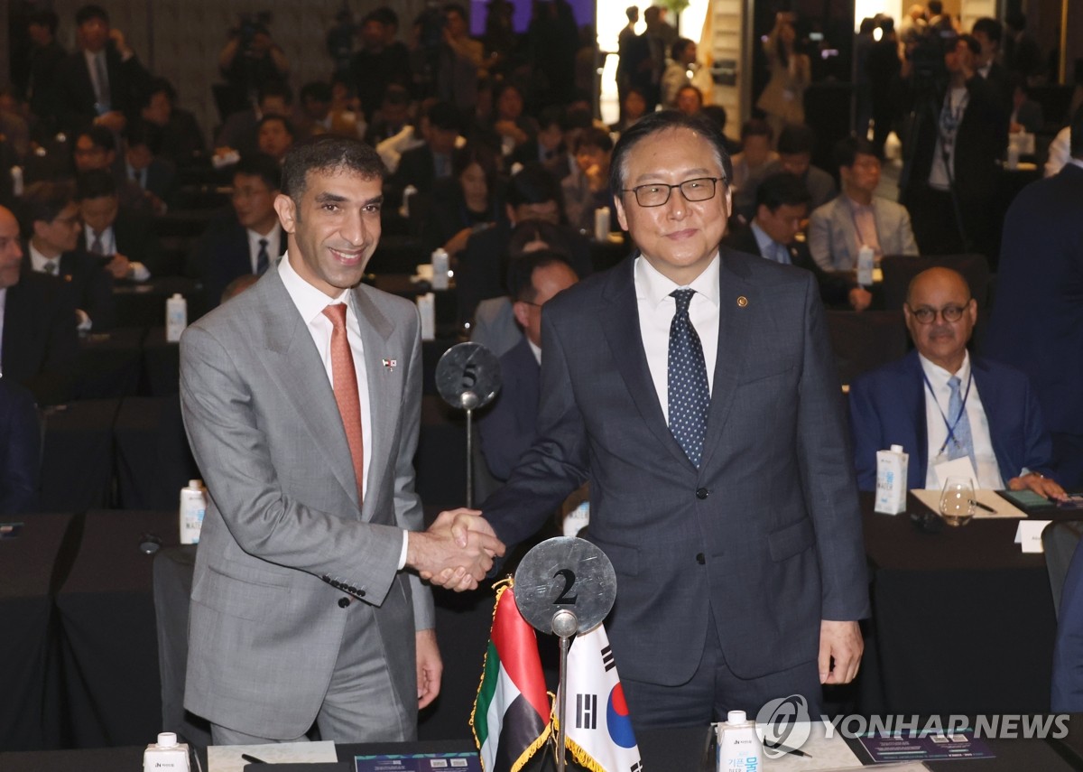 South Korean Trade Minister Cheong In-kyo (R) shakes hands with UAE Minister of State for Foreign Trade Thani bin Ahmed Al Zeyoudi at the Korea-UAE Business Investment Forum in Seoul on May 28, 2024. (Yonhap)
