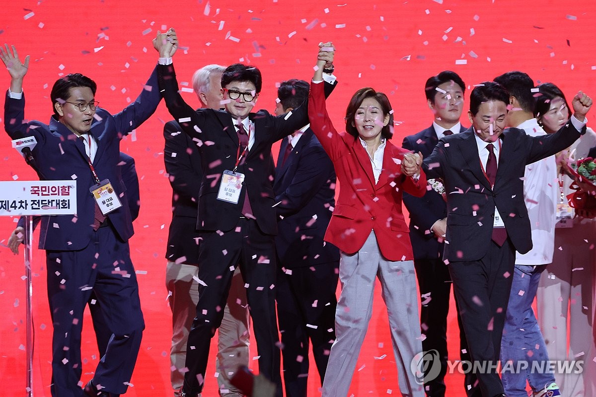 Candidatos del gobernante Partido del Poder Popular (de izq. a der.) el representante Yoon Sang-hyun, el exlíder interino del PPP Han Dong-hoon, la representante Na Kyung-won y el exministro de Tierras Won Hee-ryong, levantan las manos durante una convención nacional en KINTEX en Goyang, al norte de Seúl, el 23 de julio de 2024. (Yonhap)