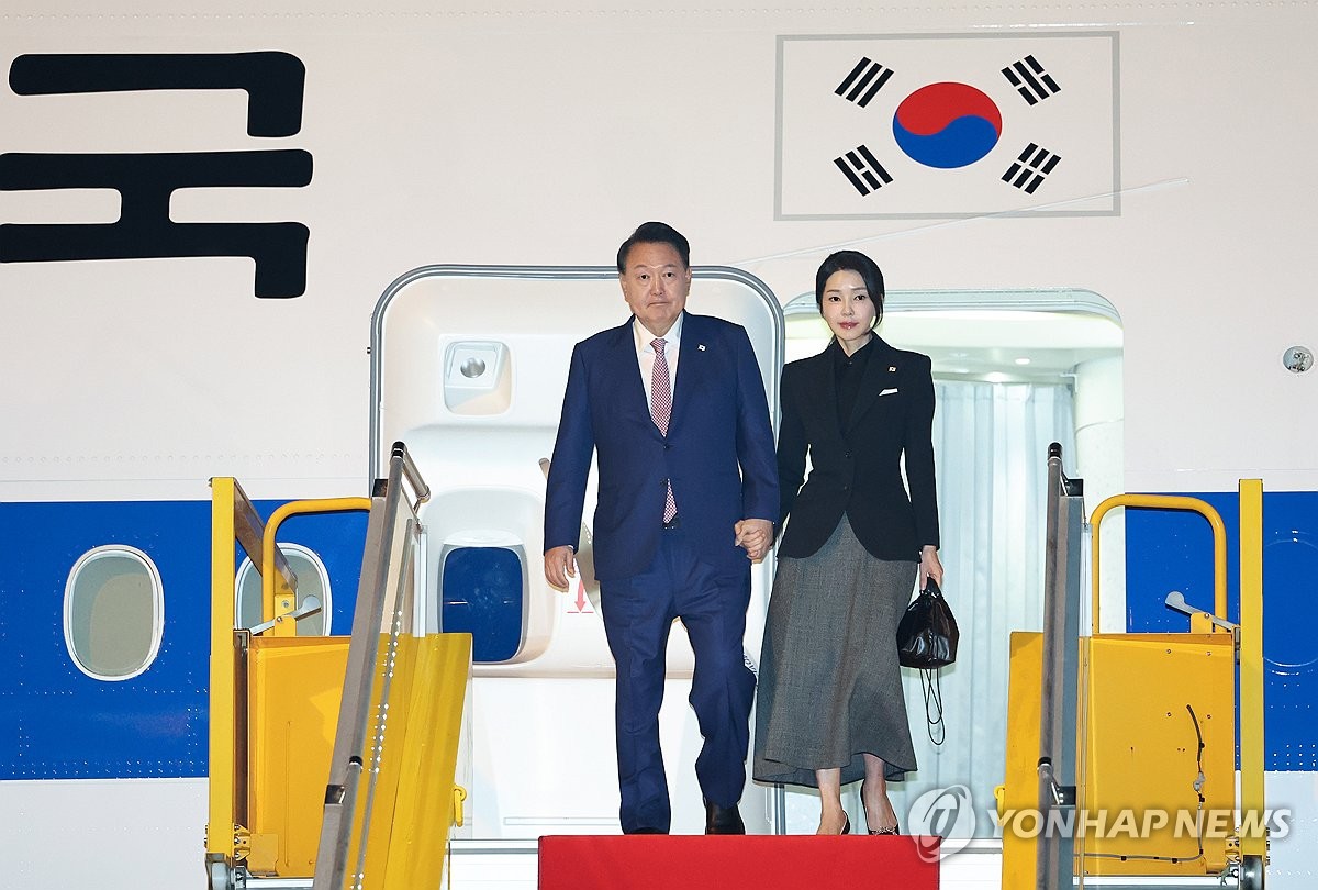 El presidente Yoon Suk Yeol (izq.) y la primera dama Kim Keon Hee llegan al aeropuerto internacional Wattay en Vientiane, Laos, el 9 de octubre de 2024. (Yonhap)