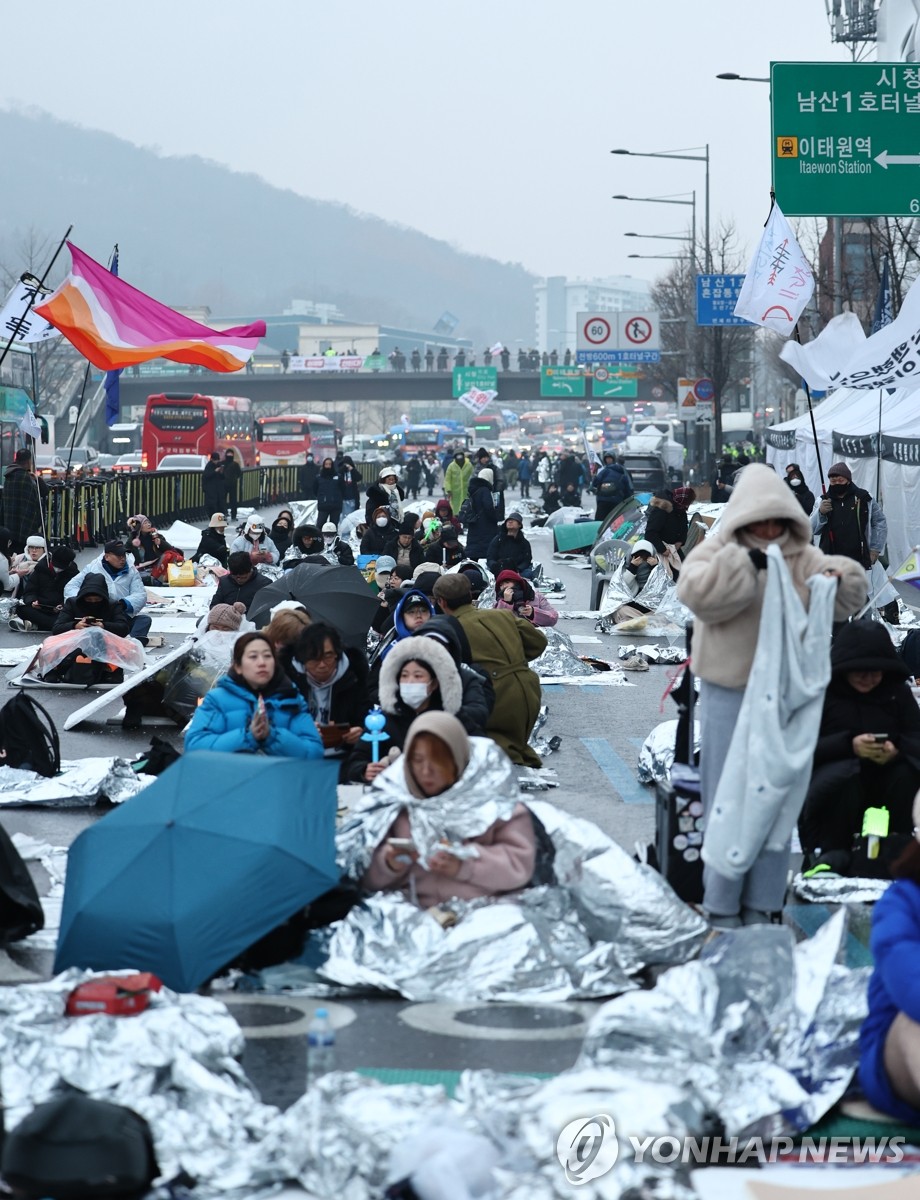 Los miembros de un grupo cívico duermen cerca de la residencia oficial del presidente acusado Yoon Suk Yeol en Seúl el 6 de enero de 2025, para pedir la ejecución por parte de la agencia estatal anticorrupción de una orden de detención por su breve declaración de ley marcial. . (Yonhap)