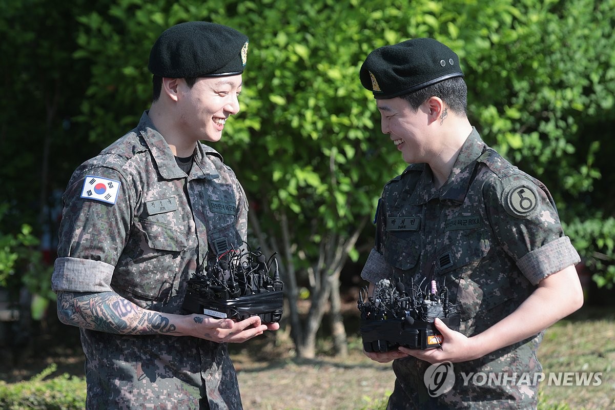 Jungkook (izda.) y Jimin, de BTS, sonríen durante una breve ceremonia celebrada, el 11 de junio de 2025, en una instalación deportiva pública en la comarca de Yeoncheon, en la provincia de Gyeonggi, para conmemorar su licenciamiento del Ejército surcoreano.